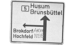 Straßenschild Richtung Brokdorf mit einem Grafitti Tag „AKW NEE“